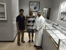 a man in a tie dye shirt stands in front of two other men in a store