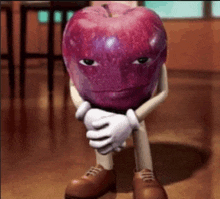 a cartoon apple with arms and legs is sitting on the floor with his hands folded .