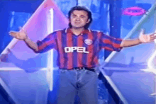 a man in an opel shirt is standing on a stage