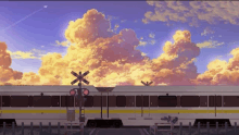 a train is going over a railroad crossing at sunset with a cloudy sky in the background .