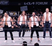 a group of men are standing in a wrestling ring with a sign that says aew galaxy