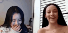 two women are laughing and talking on a video call while standing next to each other .