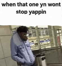 a man in a denim jacket is standing in front of a trash can with the words when that one yn wont stop yappin