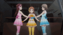 three anime girls are holding hands in a room