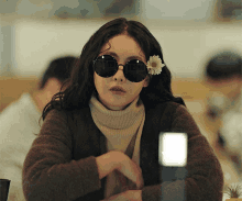 a woman with a flower in her hair wearing sunglasses