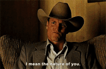 a man in a cowboy hat is sitting in a chair and says " i mean the nature of you "