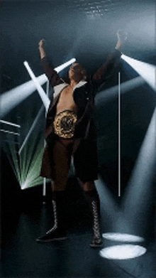 a wrestler with his arms in the air and a belt on his waist