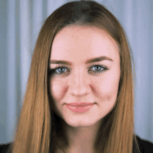 a close up of a woman 's face with long red hair