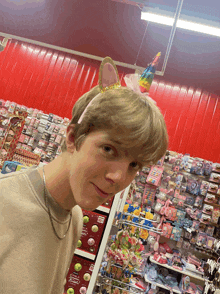 a boy wearing a unicorn headband stands in front of a candy display