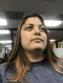 a woman wearing a blue shirt looks up at the camera