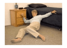 an elderly woman is laying on the floor in a bedroom .