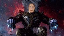 a woman in a superhero costume is sitting on a throne in the middle of space .