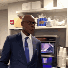 a man in a suit and tie is standing in front of a vending machine that says ' ice cream ' on it