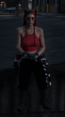 a woman wearing a red top and black pants is sitting on a wall