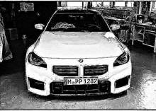 a black and white drawing of a white bmw m5 coupe parked in a garage .