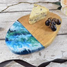 a slice of blue cheese sits on a wooden cutting board