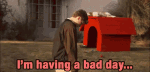 a man standing in front of a dog house with the words " i 'm having a bad day " on the bottom