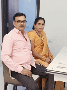 a man and a woman are sitting at a table holding hands