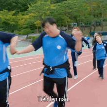 a group of people are standing on a track and one of them has the word tien written on his shirt