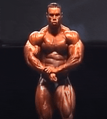 a man with a lot of muscles is standing in the dark