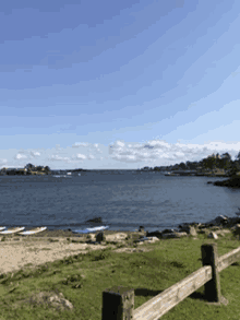 a wooden fence surrounds a beach with boats in the water