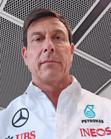 a man wearing a white shirt with petronas ineos written on it