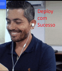 a man wearing ear buds is smiling and the words deploy com sucesso are behind him