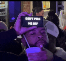 a man is taking a picture of himself with a phone that says " don 't piss me off "