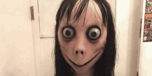 a girl wearing a mask with big eyes and a smile on her face .