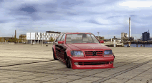 a red mercedes is parked on a brick street