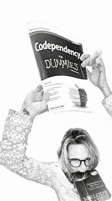 a woman is holding a book titled codependency for dummies in her hands