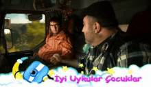 a man in a plaid shirt is talking to another man in a car with the words iyi uykular cocuklar above him