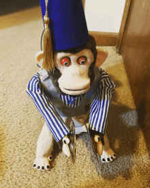 a monkey with a blue hat and striped shirt is holding scissors