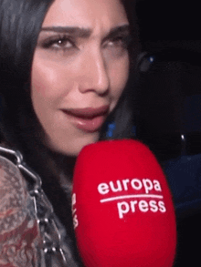 a woman is crying while holding a red microphone that says europa press