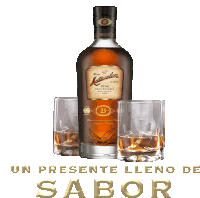 a bottle of rum sits next to two glasses with the words un presente lleno de sabor below it