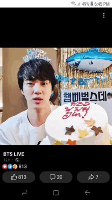 a man is holding a cake that says happy birthday jin on it