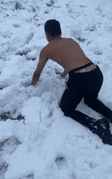 a shirtless man is crawling in the snow