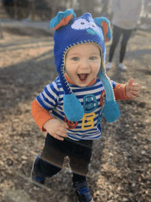 a little boy wearing a blue hat and a shirt that says bb