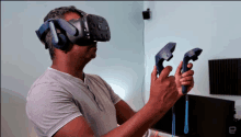 a man wearing a virtual reality headset is holding a pair of controllers