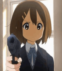 a girl is holding a gun in her hand and pointing it at the camera .