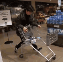 a man pushing a shopping cart in a store with a sign that says trolleys and 10 items or fewer