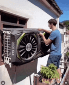 a man is holding a rtx 2060 graphics card on top of a building .