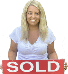 a woman in a white shirt is holding a red sign that says sold