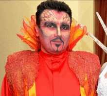 a man in a red and yellow costume with fire painted on his face