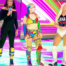 three female wrestlers are standing on a stage .