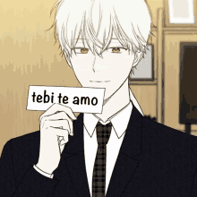 a man in a suit and tie is holding a card that says tebi te amo