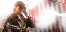 a woman in a military uniform is holding a gun and talking on a cell phone