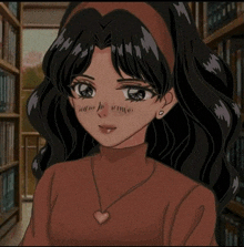 a girl with long black hair is wearing a red sweater and a heart necklace .