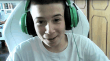 a boy wearing green headphones and a white shirt