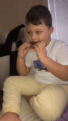 a young boy wearing a white shirt with a dinosaur on it